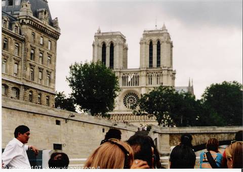 Tourists on a Seine boat in front of Notre-Dame among trees