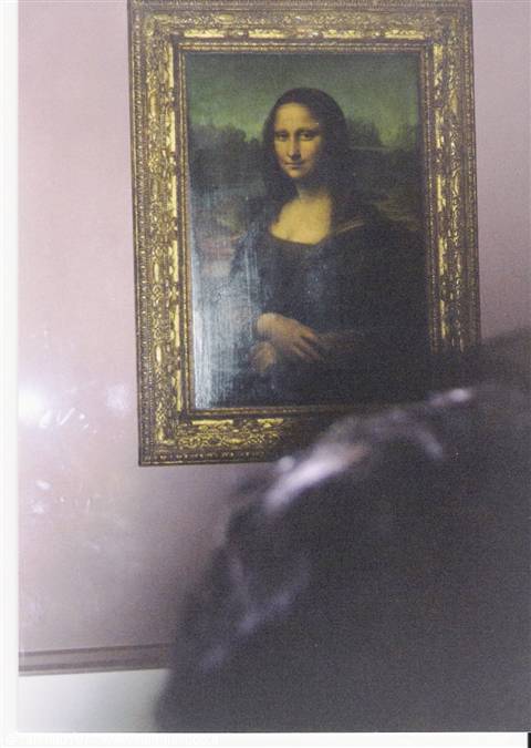 Mona Lisa in golden frame at the Louvre, blurred visitors in front