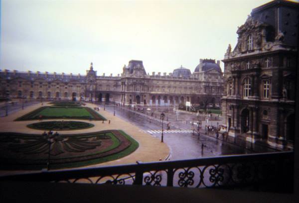 Louvre courtyard with symmetrical garden, vintage photo under grey sky