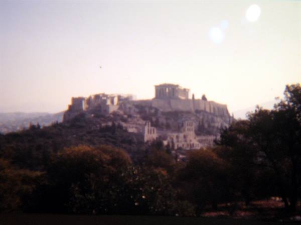 The Acropolis of Athens among trees, bright sunlight over the ancient rock