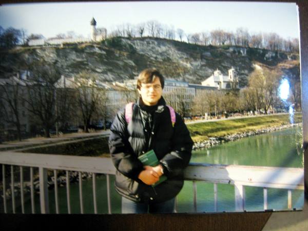 Tourist in black jacket on a bridge over the Salzach river, Salzburg