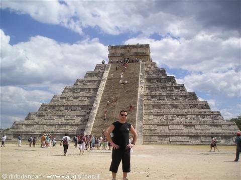Tourist posing in front of El Castillo, the Maya pyramid at Chichén Itzá, cloudy sky