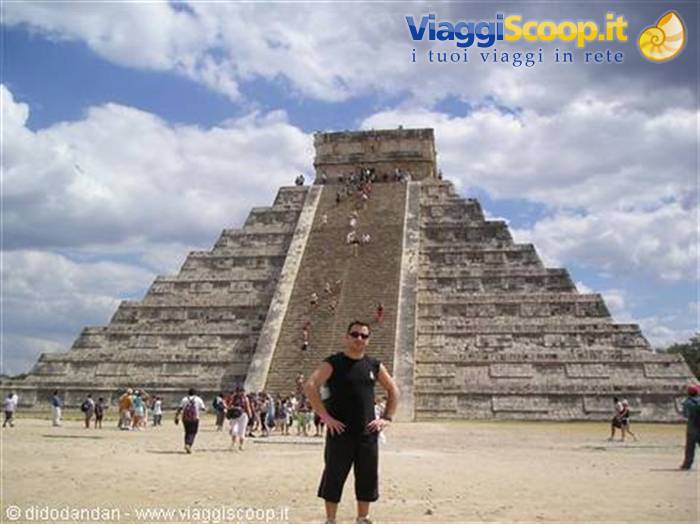Tourist posing in front of El Castillo, the Maya pyramid at Chichén Itzá, cloudy sky