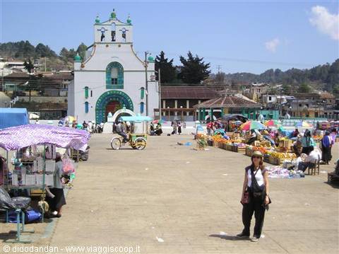 Tourist poses on the market square in front of the white green church