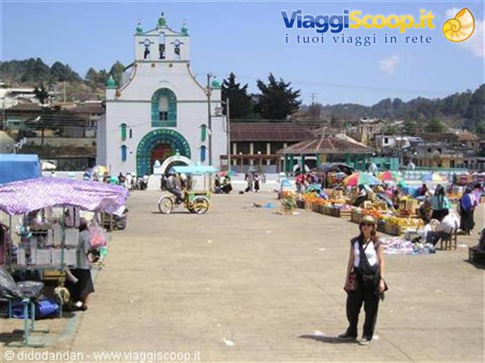Tourist poses on the market square in front of the white green church