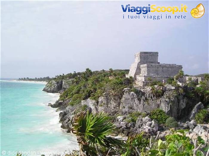 Mayan ruins of Tulum on limestone cliff above turquoise Caribbean sea, daylight