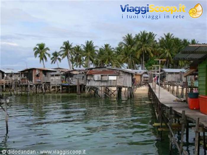 Wooden stilt houses over the water, wooden walkway, palm trees