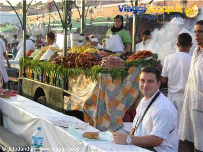 Tourist sitting at a food stall table in Marrakech's Jemaa el-Fna square