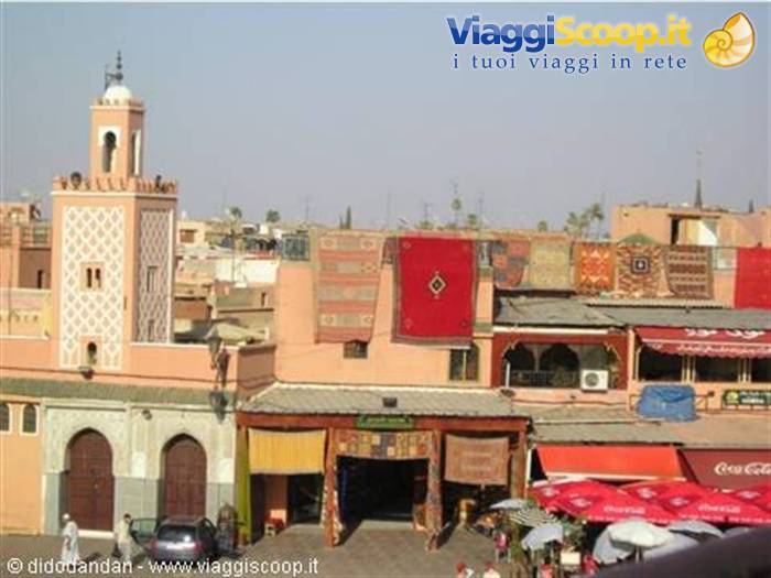 Carpets hanging on pink facades beside a minaret, Marrakech