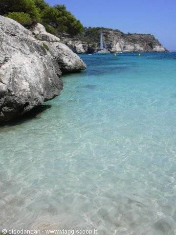 Sailboat among white rocks and turquoise water, Cala Galdana