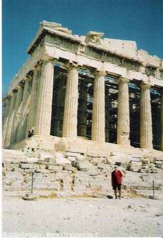 Tourist in red hat beneath the marble columns of the Parthenon, Athens