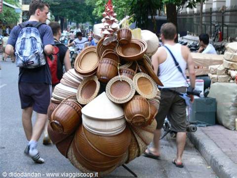Bicycle loaded with woven bamboo baskets and conical hats on a busy street