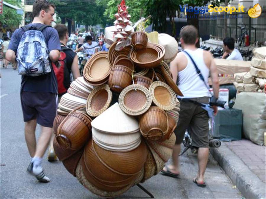 Bicycle loaded with woven bamboo baskets and conical hats on a busy street