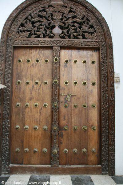 Carved wooden door with ornate lintel and brass studs, Stone Town
