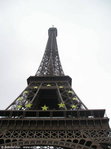 The Eiffel Tower iron lattice, seen from below, yellow stars on the pillar