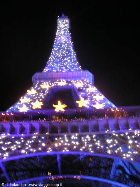 Eiffel Tower sparkling with blue lights and golden stars at night