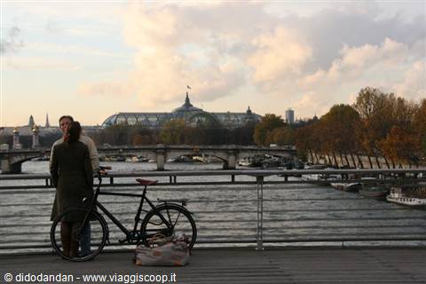 Couple with bicycle on Seine bridge, Grand Palais in the background