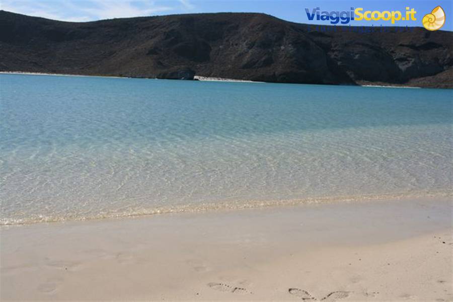 Clear turquoise water and pale sand at Balandra beach, La Paz, arid hills