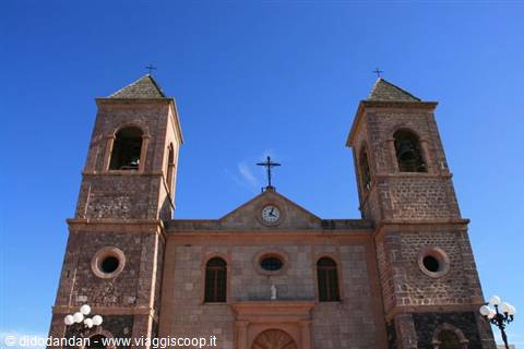 Stone church with twin bell towers and clock in Loreto