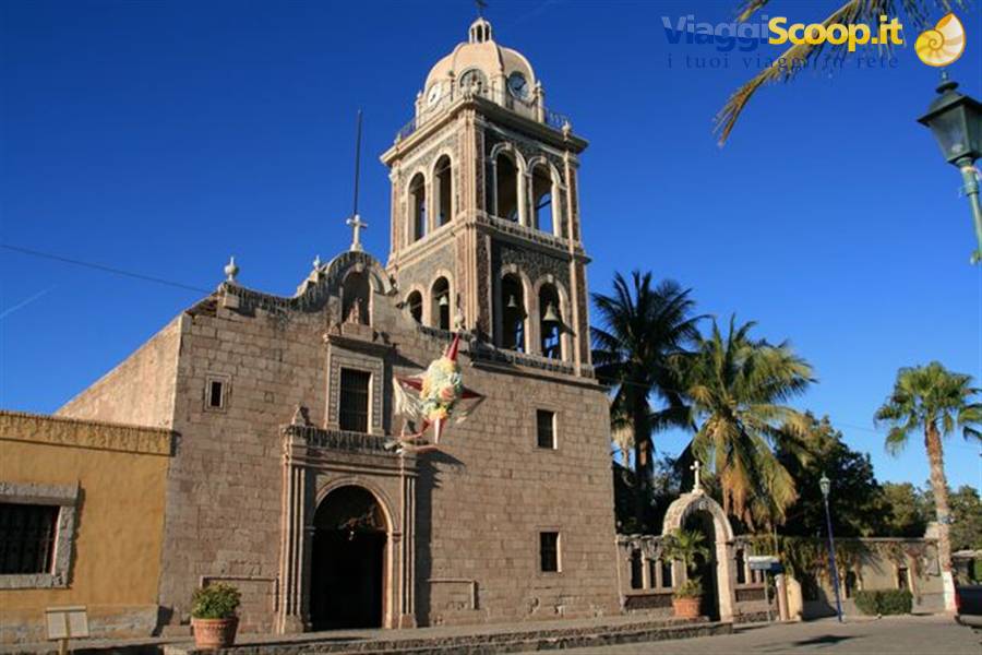 Stone mission church with bell tower and dome in Loreto