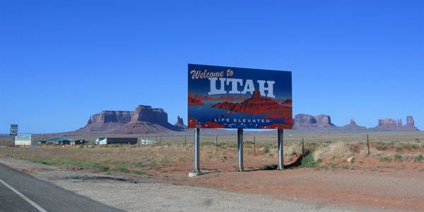 Welcome to Utah roadside sign, Monument Valley red buttes behind