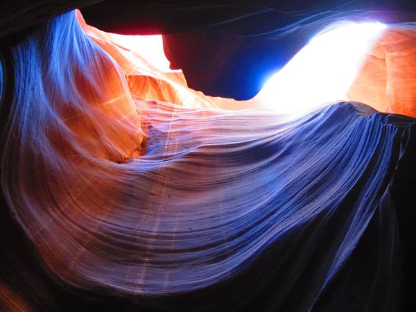 Antelope Canyon: wavy sandstone walls, blue and orange sunlight