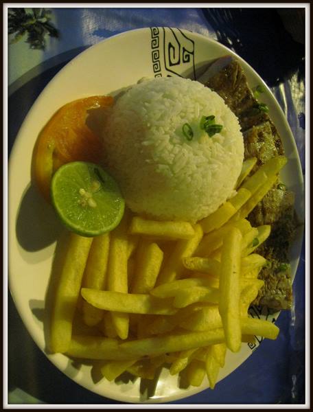Plate of rice, fries, beef and lime on a blue tablecloth