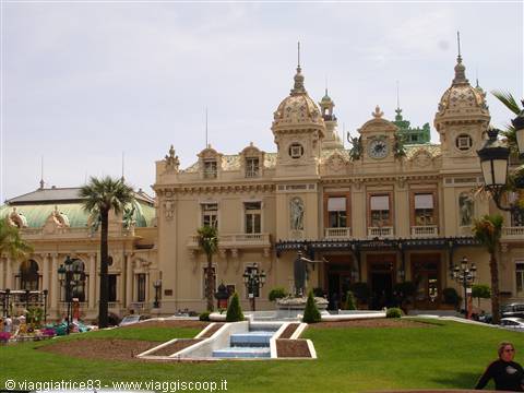 Baroque facade of the Monte Carlo Casino with fountains, hedges and palms under cloudy sky