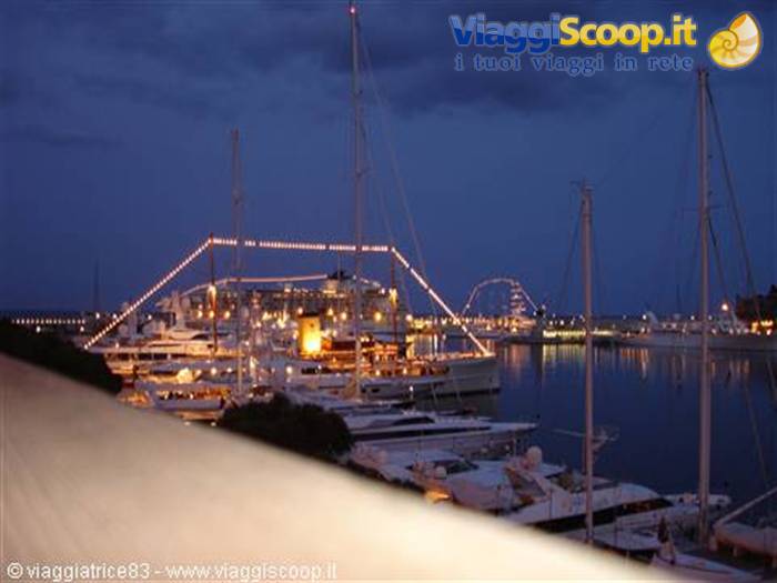 Marina at dusk: illuminated yachts and masts moored in the harbor