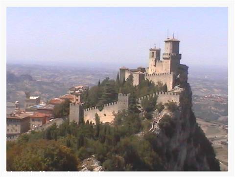 Guaita tower in San Marino on the rock, walls and houses among trees