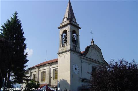 White bell tower with clock and bells, tiled roof, blue sky
