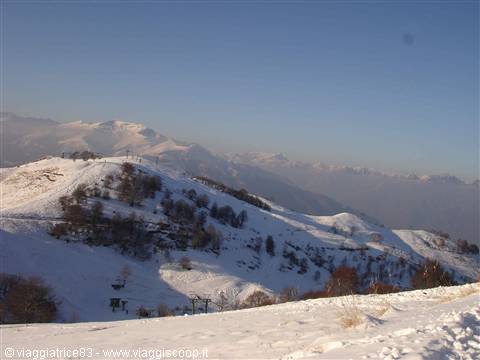 snowy mountains under clear blue sky with ski lift on the ridge