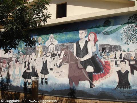 Sardinian mural: couple in traditional costume on horseback among dancing figures