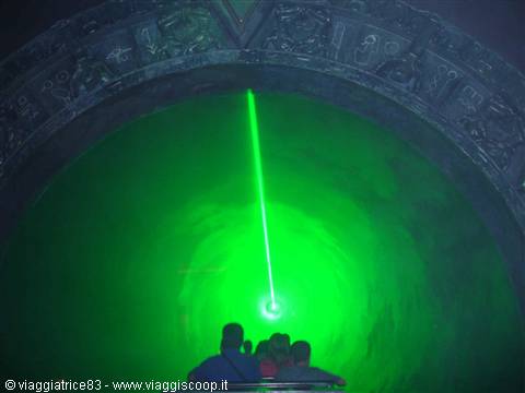 Visitors in front of the glowing green Stargate portal with laser beam