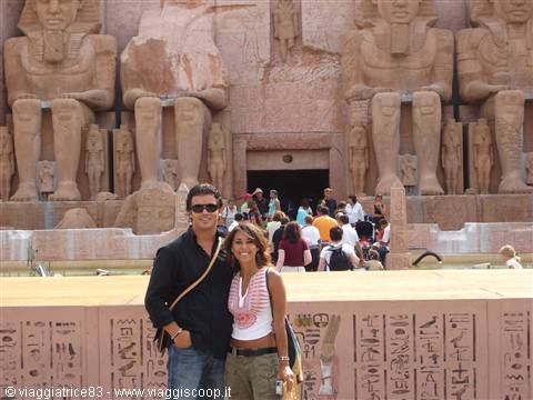 Couple in front of Ramses II colossi at Abu Simbel, bright sunlight