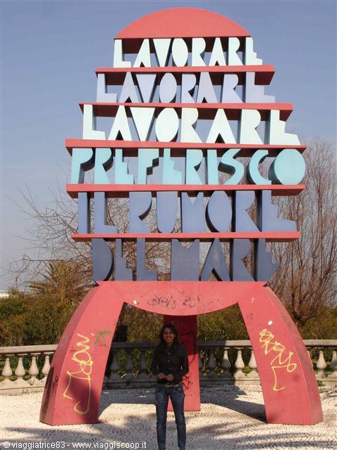 Woman under the red sculpture reading Lavorare preferisco il rumore del mare