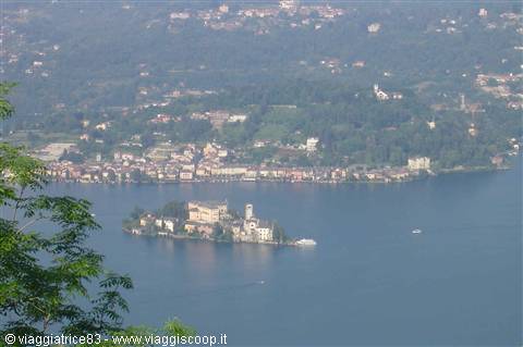 San Giulio Island on Lake Orta framed by green branches