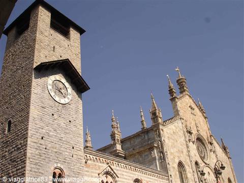 Clock tower beside Como Cathedral under a clear blue sky