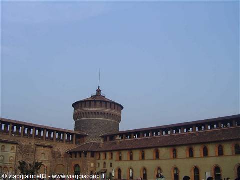 Brick tower and walls of Castello Sforzesco in Milan under a blue sky