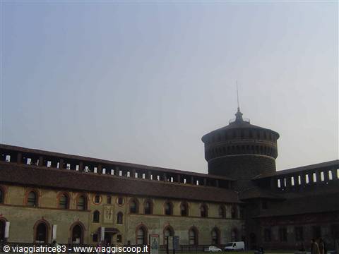 Brick tower and walls of Castello Sforzesco in Milan under hazy sky