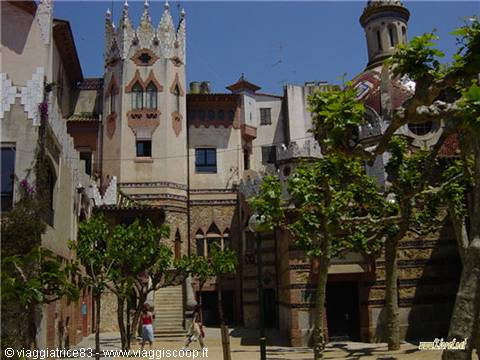 Ornate modernist tower among green trees with visitors under blue sky