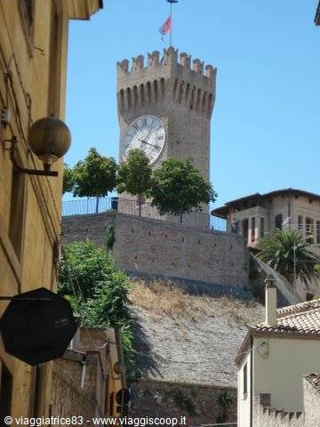 Brick clock tower with battlements rising above the old town houses