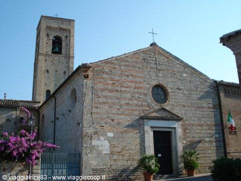 Stone church with Romanesque bell tower and blooming bougainvillea