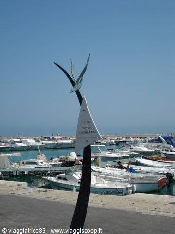 Metal seagull sculpture at the marina with moored boats