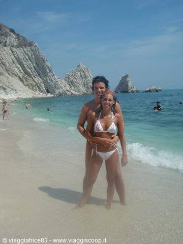 Couple in white swimwear on the sand, limestone cliffs behind, Two Sisters beach