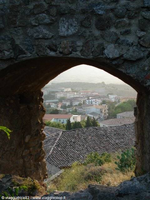 Rooftops seen through an old stone archway