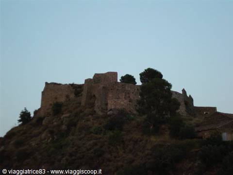Ruins of an ancient stone castle on the hill at dusk