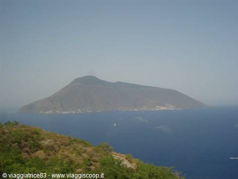 Salina island rising from the blue sea, Mediterranean vegetation in the foreground