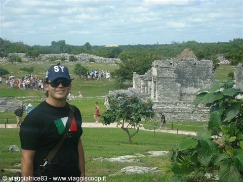 Tourist in cap standing before the Mayan ruins of Tulum in daylight