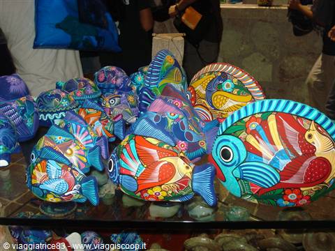 Hand-painted colorful ceramic fish displayed on a market stall